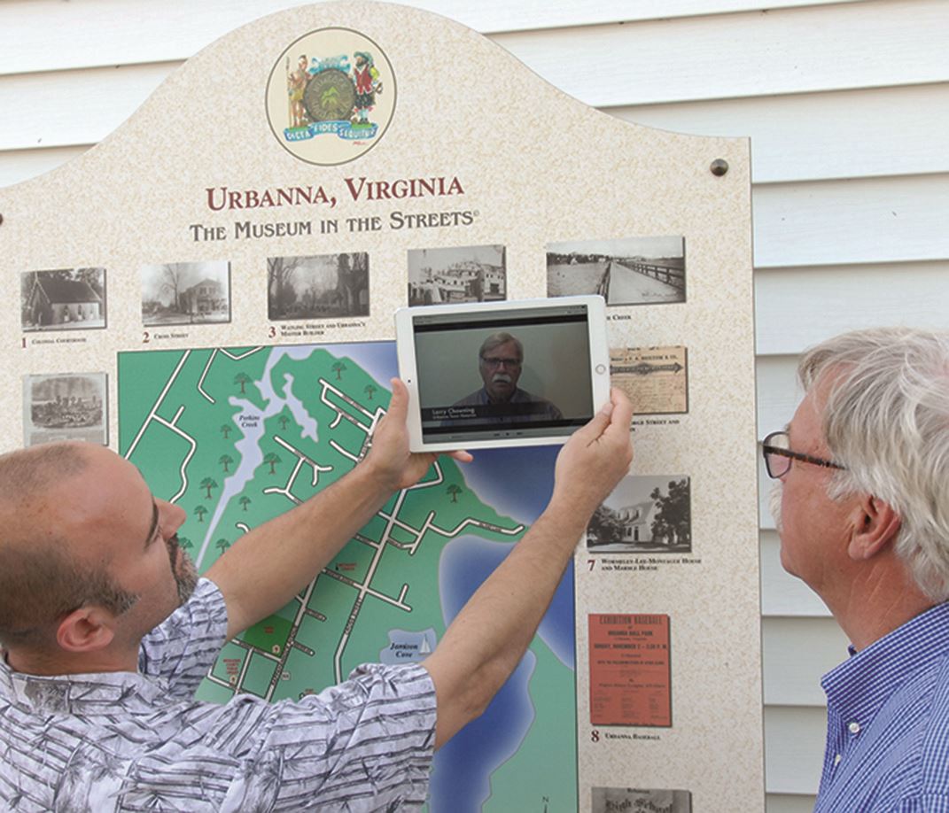Individuals using an app on their tablet for a walking history tour of Ubranna