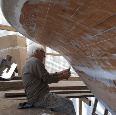 Individual working to restore a boat in an indoor location