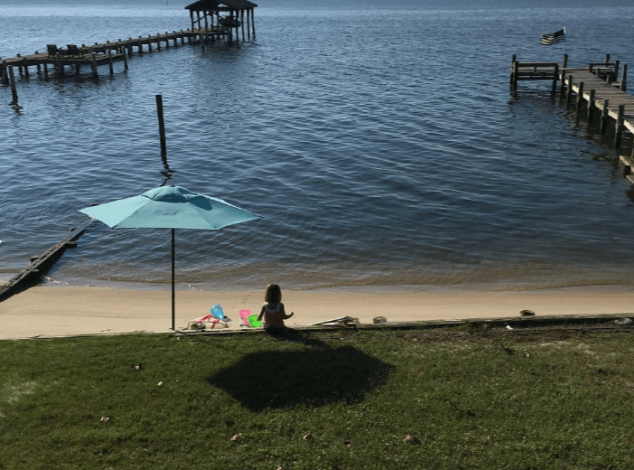Little Girl Under an Umbrella by the Beach